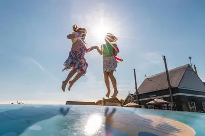 two people jumping off of a swimming pool at EuroParcs Kagerplassen in Warmond