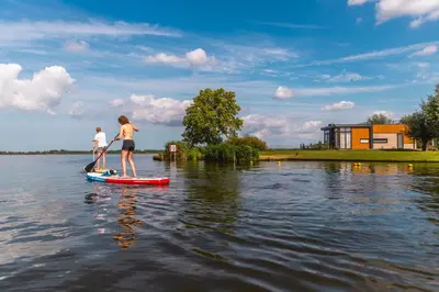 two people on a paddle board in the water at EuroParcs Kagerplassen in Warmond