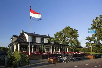 a house with a flag flying in front of it at Café Brasserie Het Heerenhuis in Het Kalf