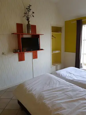 a bedroom with a bed and a tv on the wall at Café Brasserie Het Heerenhuis in Het Kalf