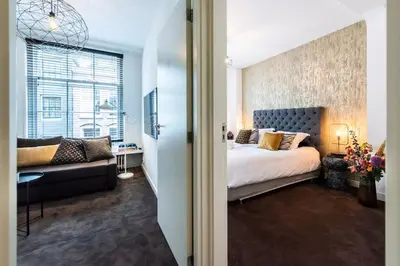 a bedroom with a large bed and a couch at Luxurious boutique suite in City Center in Amsterdam