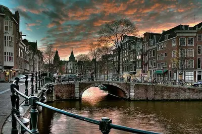 a bridge over a river in a city with buildings at Luxurious boutique suite in City Center in Amsterdam