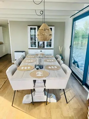 a dining room with a white table and a chandelier at Surla houseboat 