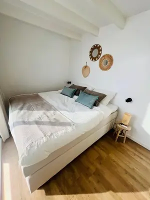 a bedroom with a large white bed with blue pillows at Surla houseboat 