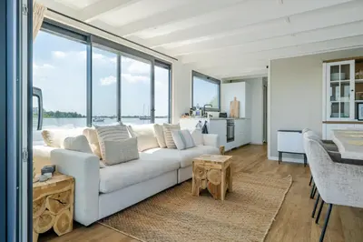 a living room with a white couch and large windows at Surla houseboat 