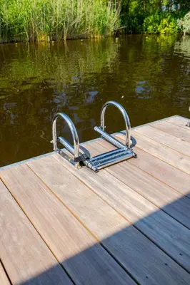 a wooden dock with two metal handles on the water at Surla houseboat 