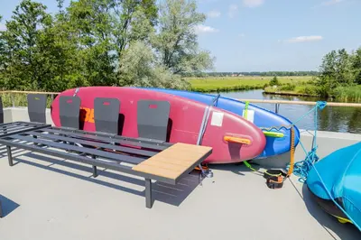 a boat sitting on a dock with a bench at Surla houseboat 