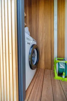 a washing machine in a room with a wooden floor at Surla houseboat 