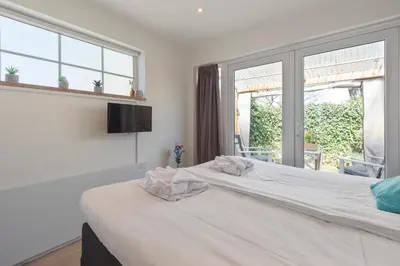 a bedroom with a large white bed with a window at Forest and Ocean in Zandvoort
