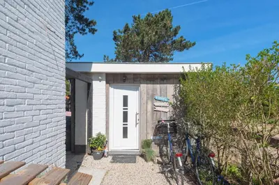 a white brick house with a white door at Forest and Ocean in Zandvoort