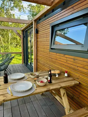 a picnic table on a deck with plates of food at TinyHouse Noorderlicht in Haastrecht