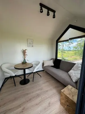 a living room with a couch and a table at TinyHouse Ochtendgloren in Haastrecht
