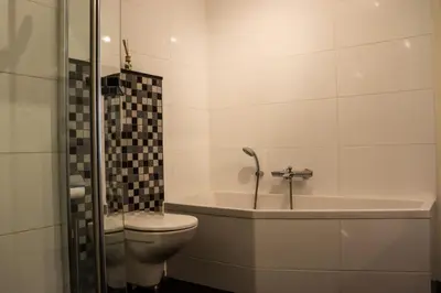 a bathroom with a toilet and a tub and a sink at Atlantis 15b in Egmond aan Zee