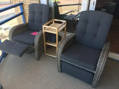 two chairs and a side table on a porch at Atlantis 15b in Egmond aan Zee