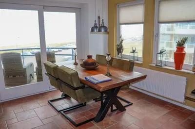 a dining room with a wooden table and chairs at Atlantis 15b in Egmond aan Zee