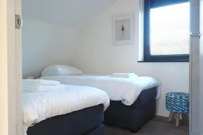 a room with two beds and a window at Villa Zon & Duin in Egmond aan den Hoef