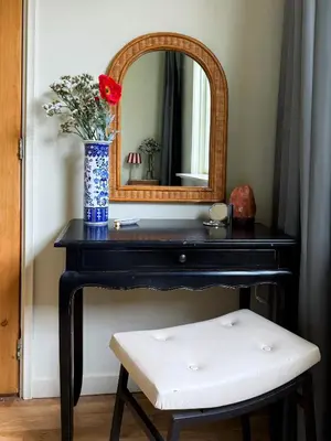 a bathroom vanity with a vase of flowers and a mirror at Sunny Side Up in Egmond aan Zee