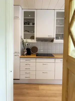 a kitchen with white cabinets and a sink at Sunny Side Up in Egmond aan Zee
