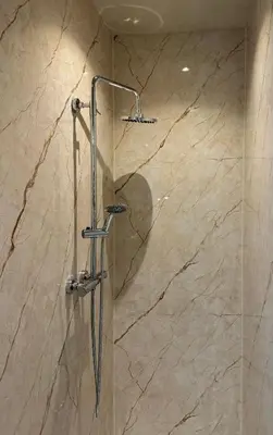a shower in a bathroom with a marble wall at Sunny Side Up in Egmond aan Zee