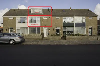 a house with a red frame in front of it at Strandhuis 122 Studio in Egmond aan Zee