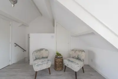 two chairs in a room with white walls at Strandhuis 122 Studio in Egmond aan Zee