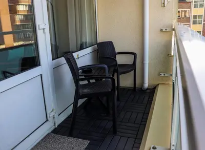 two chairs sitting on the balcony of a building at Sea la Vie in Egmond aan Zee