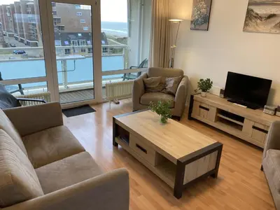 a living room with a couch and a tv at het Zeehuisje in Egmond aan Zee