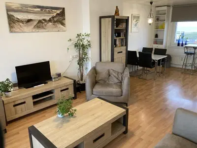 a living room with a tv and a table at het Zeehuisje in Egmond aan Zee