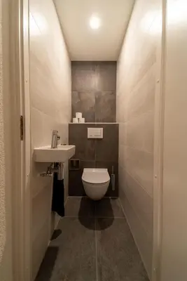 a small bathroom with a toilet and a sink at Atlantis 14b in Egmond aan Zee