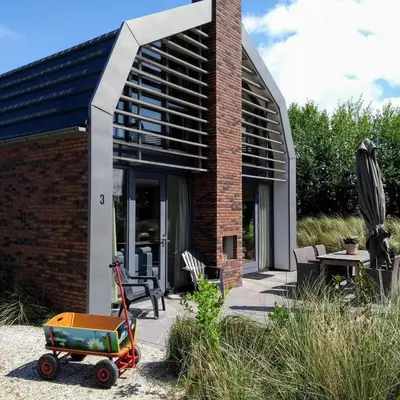 a brick house with a cart in front of it at Villa Duinhuis Zee in Egmond aan den Hoef