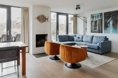 a living room with a couch and a table at Villa Duinhuis Zee in Egmond aan den Hoef