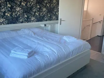 a bed with blue sheets and two towels on it at Alkmaar aan het Water in Alkmaar