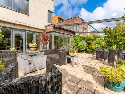 a patio with chairs and tables and plants at Alkmaar aan het Water in Alkmaar