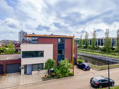a building with a car parked in a parking lot at Alkmaar aan het Water in Alkmaar