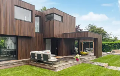 a wooden house with a lawn in front of it at Awesome Home In Vinkeveen in Vinkeveen