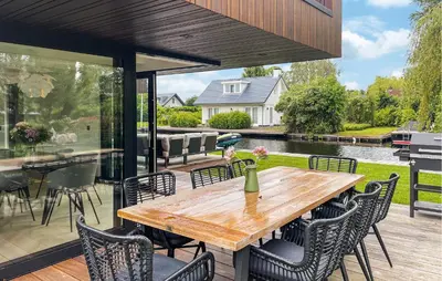 an open patio with a wooden table and chairs at Awesome Home In Vinkeveen in Vinkeveen