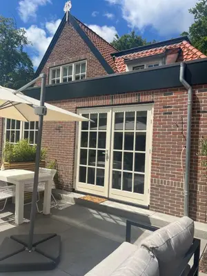 a brick house with a large window and a table at Studio Elysium in Bergen
