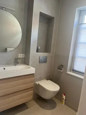 a bathroom with a toilet and a sink and a mirror at Studio Elysium in Bergen