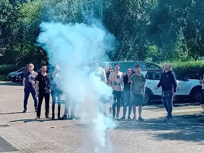 a group of people standing around a smoke bomb at Dog in Castricum