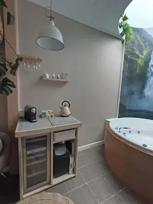 a bathroom with a tub and a sink and a toilet at Waterval Wellness-suite met Sauna! in Bodegraven