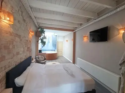 a small room with a bed and a television at Waterval Wellness-suite met Sauna! in Bodegraven