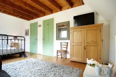 a bedroom with a bed and a dresser with a tv at Tranquil wooden house with free parking in Amsterdam