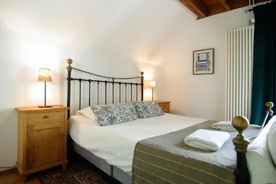 a bedroom with a bed and a lamp on a night stand at Tranquil wooden house with free parking in Amsterdam