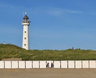 a lighthouse with three people standing in front of it at In de Duinpan in Egmond aan den Hoef