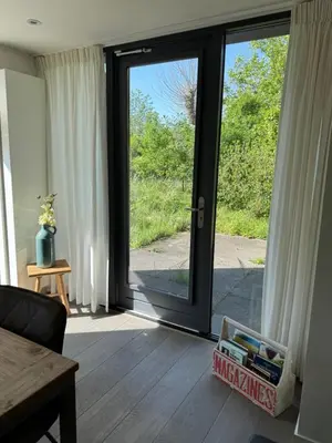a living room with a sliding glass door with a view at In de Duinpan in Egmond aan den Hoef