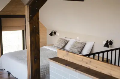 a bedroom with a bed with white sheets and pillows at B&B Hartenlust kamer de Hooizolder in Bodegraven