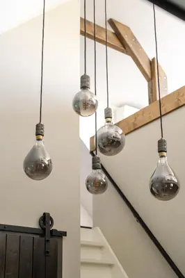 a group of glass lights hanging from a staircase at B&B Hartenlust kamer de Hooizolder in Bodegraven
