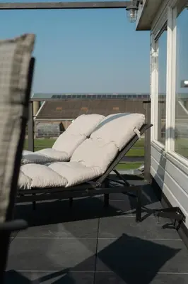 a bench sitting on the back of a porch at B&B Hartenlust kamer de Hooizolder in Bodegraven
