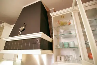 a kitchen with a shelf with dishes and a bird on it at Group Stay, 7 minutes away from Amsterdam! in Halfweg