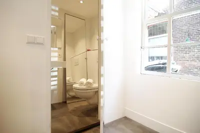 a bathroom with a toilet and a window at Group Stay, 7 minutes away from Amsterdam! in Halfweg